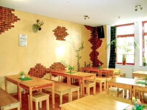 莱比锡Sleepy Lion Hostel & Apartments Leipzig的餐厅设有木桌和砖墙