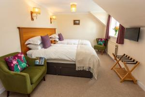 阿勒浦Eilean Donan Guest House的一间卧室配有一张床和一把绿色椅子
