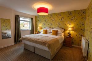 阿勒浦Eilean Donan Guest House的一间卧室设有一张黄色墙壁的大床