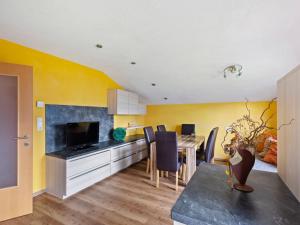 平茨高谷地霍勒尔斯巴赫Sunlit Apartment near Ski Area in Hollersbach im Pinzgau的一间厨房和带黄色墙壁及桌子的用餐室