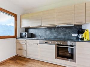 平茨高谷地霍勒尔斯巴赫Sunlit Apartment near Ski Area in Hollersbach im Pinzgau的一个带木制橱柜和水槽的厨房