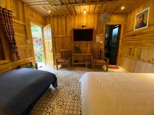 河江Ha Giang Xanh Retreat, Tour and Motorbike Rental的一间卧室配有一张床和一台平面电视