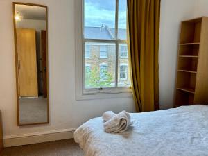 伦敦Stay in Islington的一间卧室配有一张床、镜子和窗户