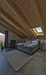 皮丁Ferienwohnung Ahornpark的一间卧室设有一张床和木制天花板