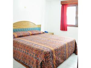芭堤雅市中心海舞宾馆的一间卧室配有一张带毯子的床和窗户