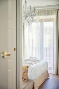 比努埃萨Casa Palacio Reina de Tardajos的一间卧室配有一张带吊灯和窗户的床。