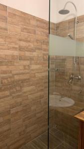 贾尔Toscan Panzió的浴室配有带浴缸的玻璃淋浴间