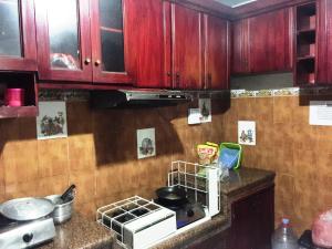 诗都阿佐SPOT ON 93880 Guest House Bu Iin Syariah的厨房配有木制橱柜和炉灶烤箱。