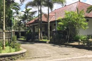 日惹Capital O 93882 The Pondok Palma Villa & Resto的棕榈树房屋和车道