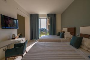 蒙特卡蒂尼泰尔梅AGRITURISMO TERRA VOLONTERI的酒店客房设有两张床和大窗户。