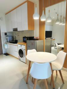 哥打京那巴鲁Cityview Studio Apartment at Kota Kinabalu City Centre的厨房配有白色的桌子和白色的椅子