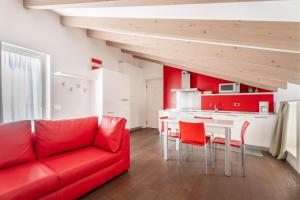 加尔达湖滨Villa Aranci Downtown的一间带红色沙发的客厅和一间厨房