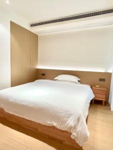 张家界Pikkie Designer's Stylish Three Bed Room Apartmemt的卧室配有一张白色大床