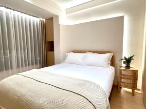 张家界Pikkie Designer's Stylish Three Bed Room Apartmemt的卧室配有白色的床和窗户。