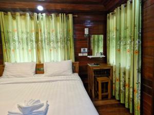 Ban KoYungthong Baan Suan Resort的一间卧室配有带窗帘和镜子的床