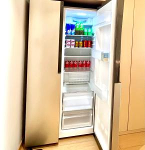 张家界Pikkie Designer's Stylish Three Bed Room Apartmemt的装满饮料和苏打水的开放式冰箱