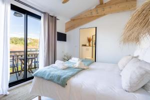 比亚里茨Biarritz Surf Lodge Chambre d'hôtes的卧室设有一张大白色床和阳台