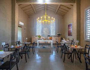 切塔尔多Relais Borgo Elissa的大型客房配有桌椅和吊灯。