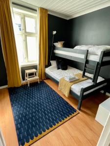 哈尔登Sentral og fargerik bygårdsleilighet的卧室配有两张双层床和地毯。