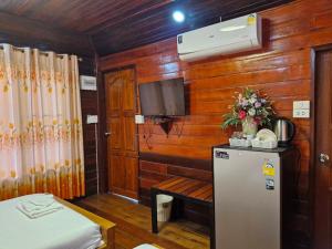 Ban KoYungthong Baan Suan Resort的一间小房间,配有冰箱和电视