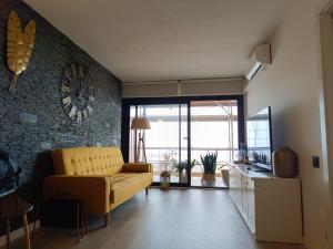 滨海阿雷尼斯Elegant apt 4 pax 1 min from the beach with Wifi的客厅配有沙发和墙上的时钟