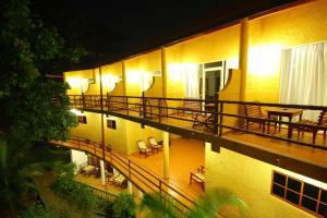 本托塔拉努纳阿育吠陀度假酒店的公寓大楼设有带桌椅的阳台