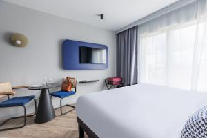 鲁瓦西昂法兰西Appart'City Collection Paris Roissy CDG Airport的一间酒店客房,配有一张床和一台电视