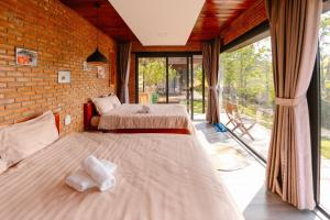 大叻Scent Bungalow - Village的带大窗户的客房内的两张床
