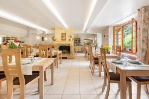 Brousse-le-ChâteauHôtel Restaurant Le Relays du Chasteau - Logis Hôtel的一间带桌椅和壁炉的用餐室