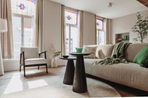 登博斯The Guest Apartments - Lange Putstraat的客厅配有沙发和桌子