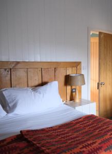 纽波特利兹迈德酒店的一间卧室配有一张大床和木制床头板