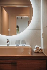 登博斯The Guest Apartments - Lange Putstraat的浴室水槽,配有2个玻璃杯和镜子