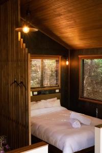 拉格伦Modern, Cosy Hideaway - Rua Nuka Raglan的一间卧室设有一张床和两个窗户。