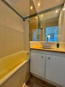 泰晤勒·苏尔·梅尔Rousseau的一间带水槽、浴缸和镜子的浴室