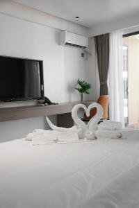 邦劳Willander Resort的一间卧室配有一张带两个白色天鹅的床