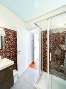 佩拉Mauremile的一间带玻璃淋浴和水槽的浴室