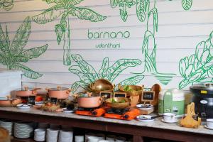 乌隆他尼Blu Monkey Brown House Udonthani的餐桌上的自助餐,包括植物和锅