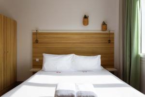 弗雷瑞斯L'Oasis Hotel的卧室配有白色的床和木制床头板