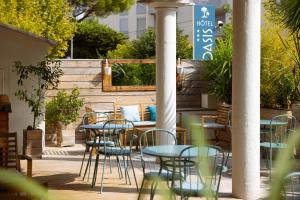 弗雷瑞斯L'Oasis Hotel的一个带桌椅的庭院和围栏