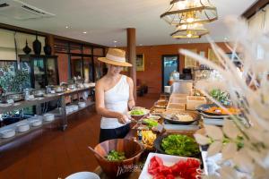 莱卡邦Divalux Resort & Spa Bangkok, Suvarnabhumi Airport-Free Shuttle的身着帽子的女人站在自助餐后