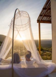 克兰威廉Simbavati Cederberg Ridge的一对夫妇躺在天蓬床上,欣赏日落美景