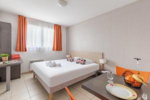 维特罗勒Appart'City Classic Marseille Aéroport - Vitrolles的酒店客房配有白色的床和桌子