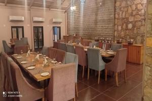 乌代浦Banjara Hills Jungle Lodge的大型用餐室配有长桌和椅子