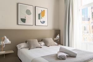 卡塔赫纳Apartamentos Turísticos Plaza del Rey的一间卧室配有带两个枕头的床和窗户