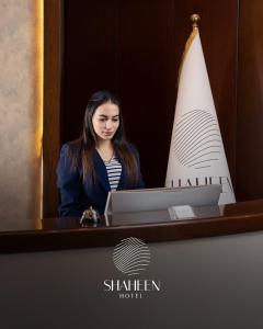 巴格达Shaheen Hotel Baghdad的坐在桌子前的手提电脑的女人