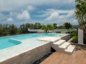 邦涛海滩Family 2bd apartments in Laguna SkyPark的一座带石墙和砖墙的游泳池
