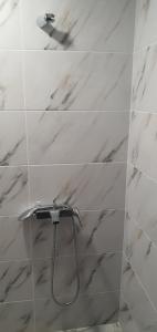 RazgradНощувки вип класа的浴室铺有白色大理石瓷砖,设有淋浴。