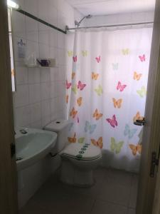 萨洛Hostal Tahiti RS的浴室设有卫生间和带蝴蝶的浴帘