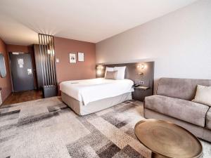 波尔多美居波尔多紫胶酒店的酒店客房,配有床和沙发