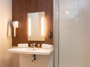 圣艾蒂安迪鲁夫赖IBIS STYLES Rouen Parc Expos Zenith的一间带水槽、镜子和淋浴的浴室